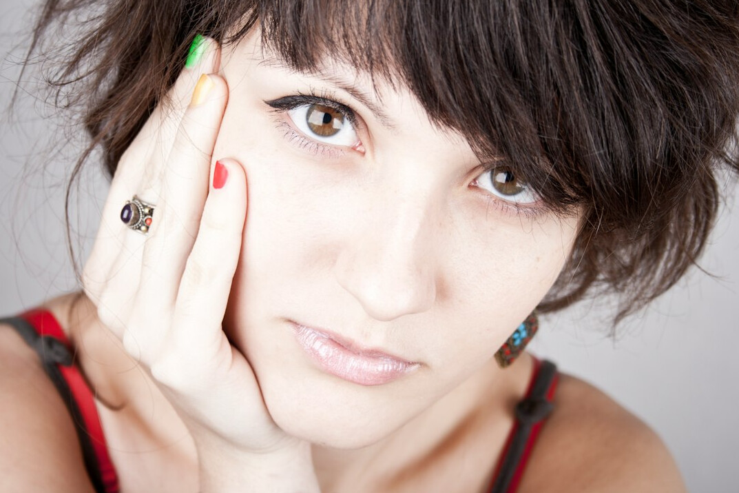 Studio portrait of a smiling woman with short brown hair